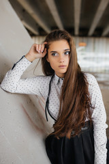 Portrait of a beautiful girl staying near the wall  under the bridge. Vertical . - 179116195