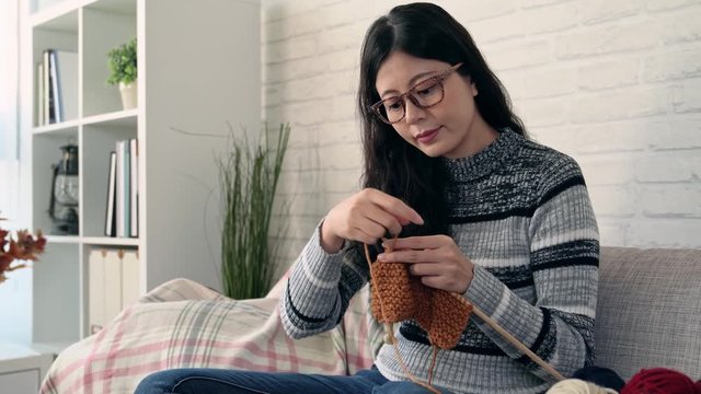 asian woman knitting and looking the weather