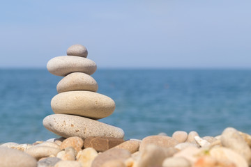 Fototapeta na wymiar Pebble tower standing on the left on the sea beach