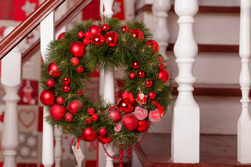 Christmas wreath with red balls and evergreen boughs on wooden stairs decoration