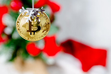 Bitcoin gold coin on the background of the Christmas tree.