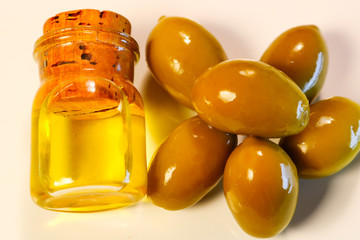 green olives in oil. man's hand filling oil