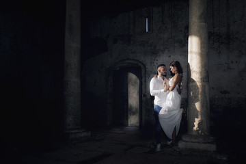 Hombre y mujer enamorados en un templo antiguo iluminados por la luz del sol al atardecer