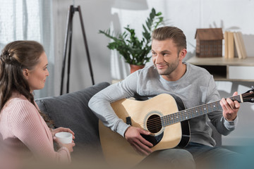 Obraz premium Boyfriend playing guitar to girlfriend