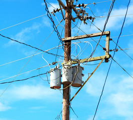 a electric pole with transformer and wire  the cloudy sky