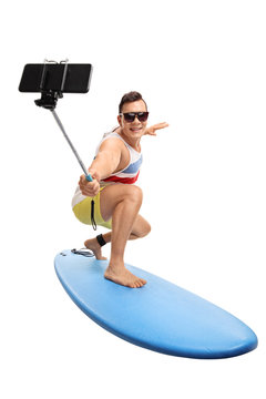 Young man surfing and taking a selfie with a stick