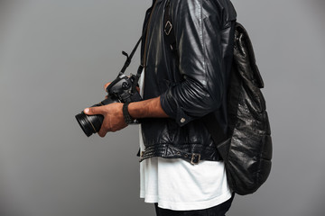Fototapeta na wymiar Cropped photo of stylish african man with backpack holding photo camera