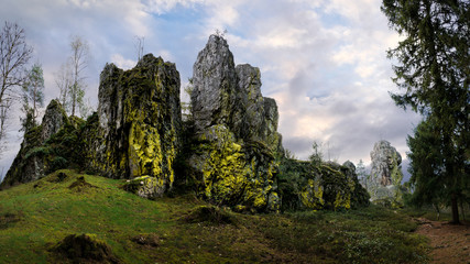 Quartz rock formation with peaks covered with moss and a cloudy background.
