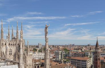 Fototapeta premium White marble statues on the roof of famous Cathedral Duomo di Milano on piazza in Milan, Italy