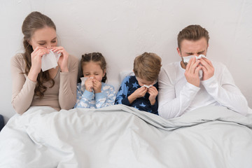 family blowing noses in napkins