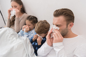 family blowing noses in napkins