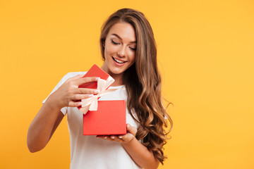Portrait of a happy smiling girl opening gift box