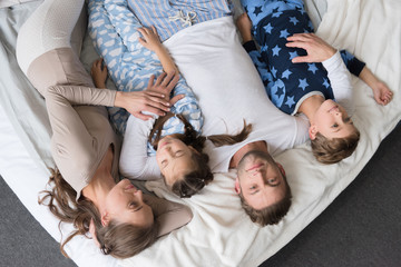 family with children lying on bed
