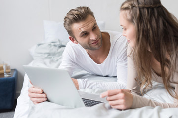 Couple lying with laptop