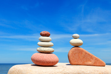 Stones balance on a background of blue sky and sea