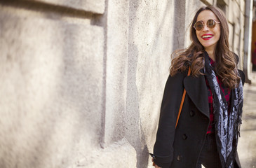 stylish brunette young woman with red lips in fashionable sunglasses posing