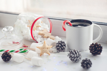 Christmas cookies and cup of tea, on window sill at home
