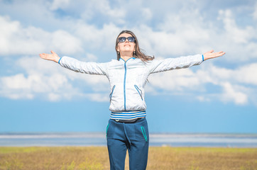 Young woman smiling in the midst of a orange lawn, she looks at the camera, so carefree. Steppe landscape. Baskunchak lake at background. Travel picture