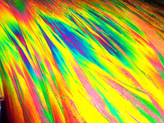 Crystal layer on microscope object glass, seen in polarized light. This causes random unforeseeable color effects.
