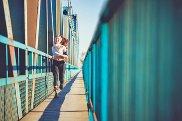 Young Fitness Woman Running over Bridge