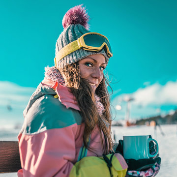 Woman with cup of coffee or tea enjoying the winter day on mountain