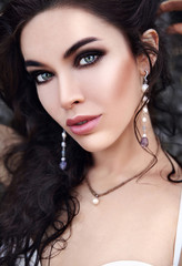 portrait of beautiful caucasian  woman model with evening makeup and dark long hair posing outdoors