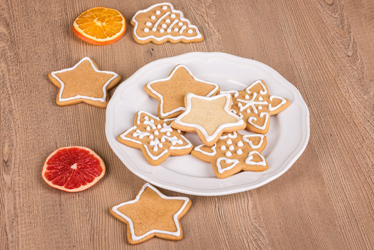 Christmas cookies with decoration /
Still life with decorated Christmas cookies in a plate on a wooden background