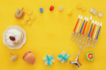 Top view image of jewish holiday Hanukkah background with traditional spinnig top, menorah (traditional candelabra)