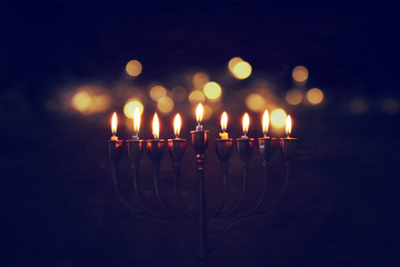 Fototapeta premium Niski klucz obraz tła żydowskiego święta Chanuka z menorą (tradycyjne świeczniki) i płonącymi świecami