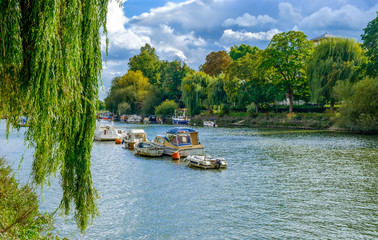 Moored boats on the river Thames in summer on a overcast day, Richmond London U.K