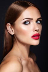 Portrait of beautiful girl model with evening makeup and romantic hairstyle. Red lips