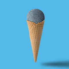 Ice cream cone with christmas ball on bright blue background. Minimal style.  Holiday concept.