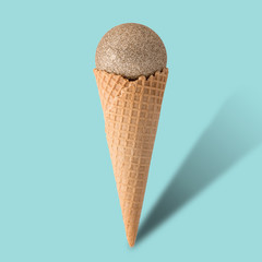 Ice cream cone with christmas ball on bright blue background. Minimal style.  Holiday concept.