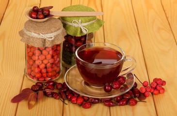 Stocks of berries in jars, cup of tea, against the background of table