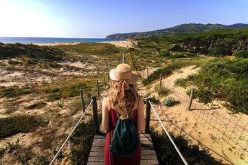 Fototapeta na wymiar Yougn woman in red dress traveling in Portugal