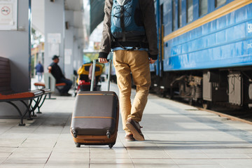 Young man carrying his luggage in the train station,traveling concept.,copy space. Customs near the...