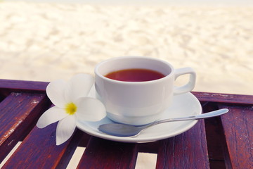  Relaxing vacation Maldives vacation. Hands bring a cup of indian tea. Tea near the Indian ocean. Spa relaxing time at the beach with white sand. Hot beverage near the sea. Cup of tea on the vacation.