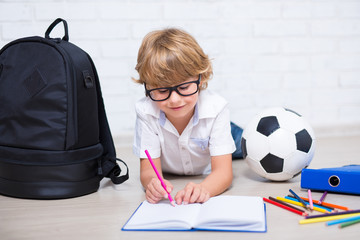 little boy in glasses doing homework