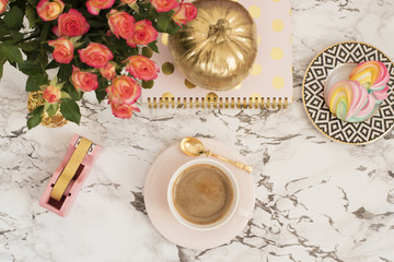 Feminine workplace concept. Freelance workspace in flat lay style with coffee, flowers, golden...