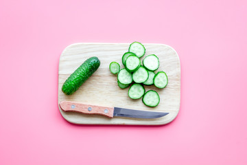 Cut fresh cucumbers. Pink background top view copyspace