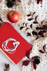 Cozy home with cup of coffee and a book. Hygge style. Mug of black coffee wrapped in warm scarf on wooden board. Top view, vintage style, Still life.