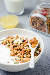 Low carb honey granola yogurt bowl on dark concrete background. Selective focus, copy space.