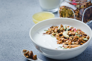 Oil free vegan homemade granola with yogurt on dark concrete background. Selective focus, copy space.