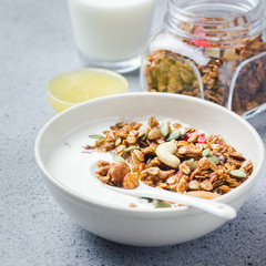 Crunchy peanut butter granola with honey  oats and yogurt on dark concrete background.  Selective focus, copy space.