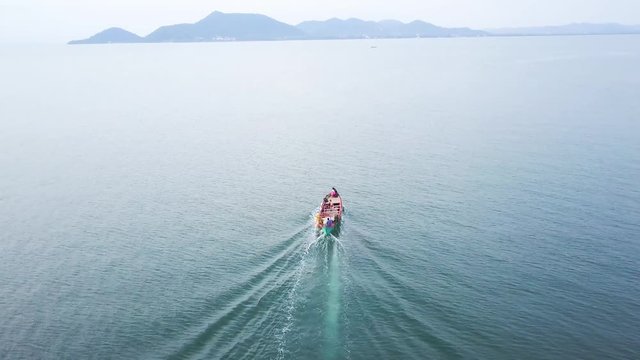 Aerial camera follows a wooden tourist ferry boat as it travels across the Gulf of Siam to the mainland, Kep, Cambodia.