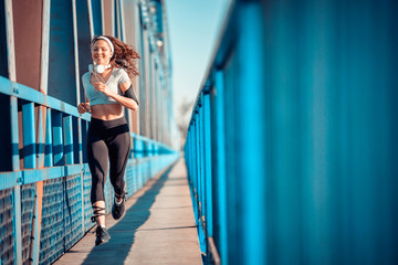 Young Fitness Woman Running over Bridge