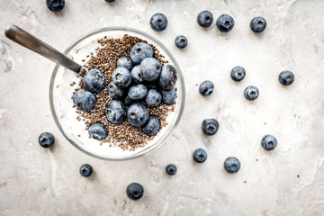 How to eat chia seeds. Dessert with yogurt, chia and blueberries on grey background top view