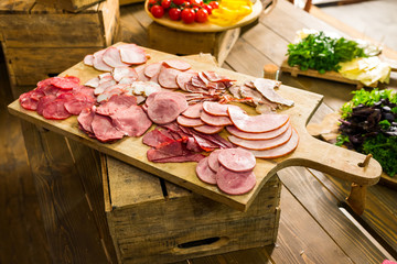 meat cut on a wooden board of a banquet table