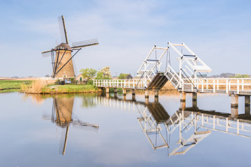 Windmill and sluice on the canal, Kinderdijk, Molenwaard municipality, South Holland province, Netherlands