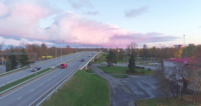 Aerial footage of traffic, cars and buses on the bridge, Jõhvi, Estonia.  Beautiful sunset with amazing pink clouds over the city.